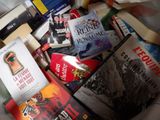 a pile of books that are sitting on a bed