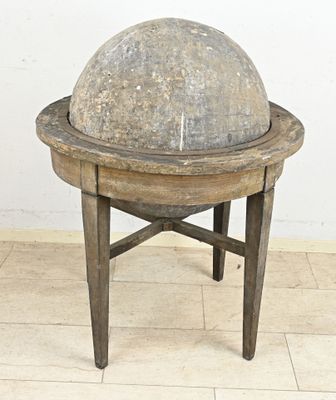 une boule de pierre posée sur un socle en bois