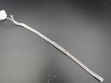 gros plan d'un bracelet en argent sur une surface noire