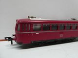 un train rouge posé sur une table blanche, sur fond blanc