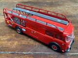 un bus rouge à deux étages posé sur une table en bois
