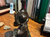 a statue of a woman sitting on top of a wooden table