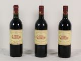trois bouteilles de vin rouge sont alignées sur une table