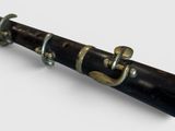 a black and gold clarinet on a white surface