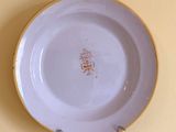 a white plate with a yellow rim on a yellow wall