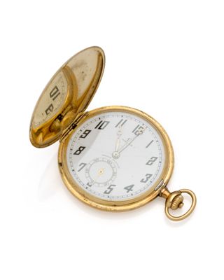 une montre de poche en or posée sur une surface blanche