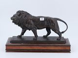 une image représentant une statue de lion posée sur un socle en bois