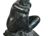 statue of a man sitting on a rock with his hands on his knees