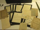 many old papers on a table with scissors and a pair of scissors