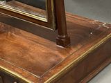 a mirror on top of a wooden dresser with a drawer underneath it