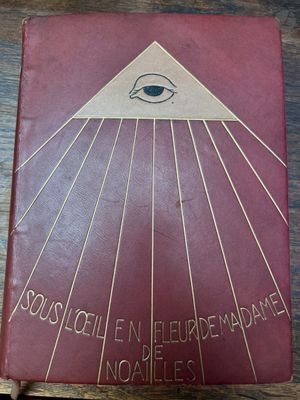 un vieux livre posé sur une table en bois, avec l'image d'un œil