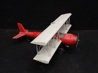 un petit avion en jouet posé sur une surface noire