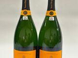 two bottles of champagne sitting next to each other on a table