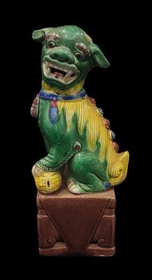 chinese figurine of a dog on a box with a black background