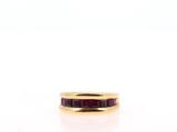 a close up of a gold ring with a red stone in it
