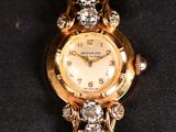 a close up of a watch on a black cloth