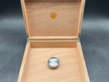 a wooden box with a watch inside of it on a table