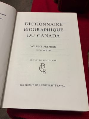 Quelqu'un est en train de lire un livre sur une table recouverte d'une nappe rouge.