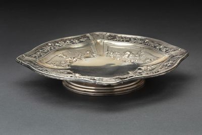 une assiette en argent antique avec un motif de fleur