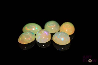 un groupe de perles oplites blanches posées sur une surface noire