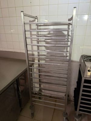 une étagère métallique au milieu d'une cuisine, à côté d'une cuisinière