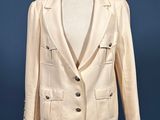 beige jacket on a mannequin stand against a blue wall