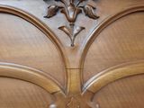 a bed with a wooden headboard with flowers on top of it