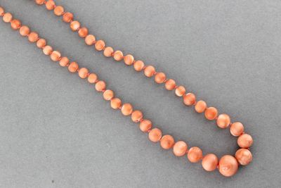 Collier de boules de corail en chute.