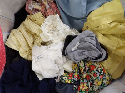 a pile of clothes in a basket on the floor