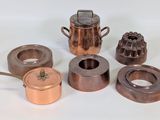 de nombreux types de casseroles et poêles en cuivre sur la table