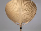 un éventail en bois posé sur une surface blanche