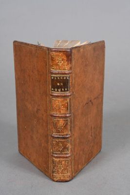an old book sitting on top of a table next to a white wall