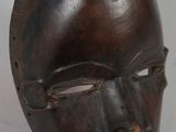 gros plan d'un masque en bois sur une surface blanche