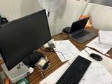 un bureau sur lequel se trouvent un ordinateur, un clavier, une souris et d'autres objets