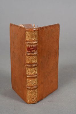 an old book with a brown cover sitting on top of a table