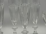 several empty wine glasses and a bowl on a white surface