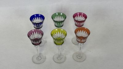 four wine glasses are lined up in a row on a white surface