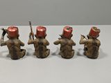 three small figurines of monkeys with hats on their heads