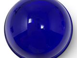 blue glass ball on a white surface with a white background