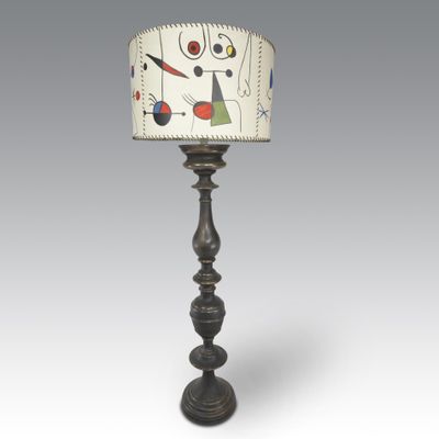 a black lamp with a white shade on top of it