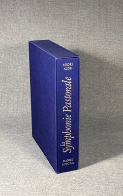 a blue book sitting on top of a table next to a gray wall
