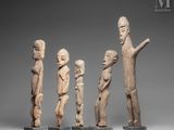a group of four carved wooden figures of different sizes and shapes