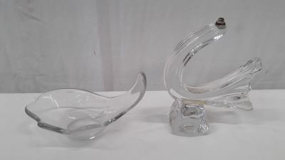 paire de plats en verre transparent en forme de cygne posés sur un support blanc