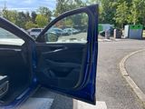a blue car with its door open on the side of the road