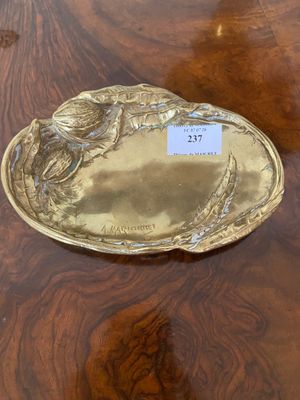 a gold plate on a wooden table with a name tag on it