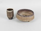 a small bowl and a small cup sitting next to each other
