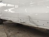 a white van parked in a parking lot with its door open