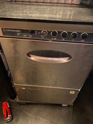 une canette de soda posée à côté d'un lave-vaisselle dans une cuisine