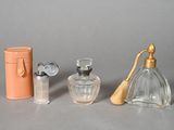 three bottles of perfume and a case on the table