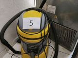 a yellow vacuum cleaner sitting on the floor next to a door